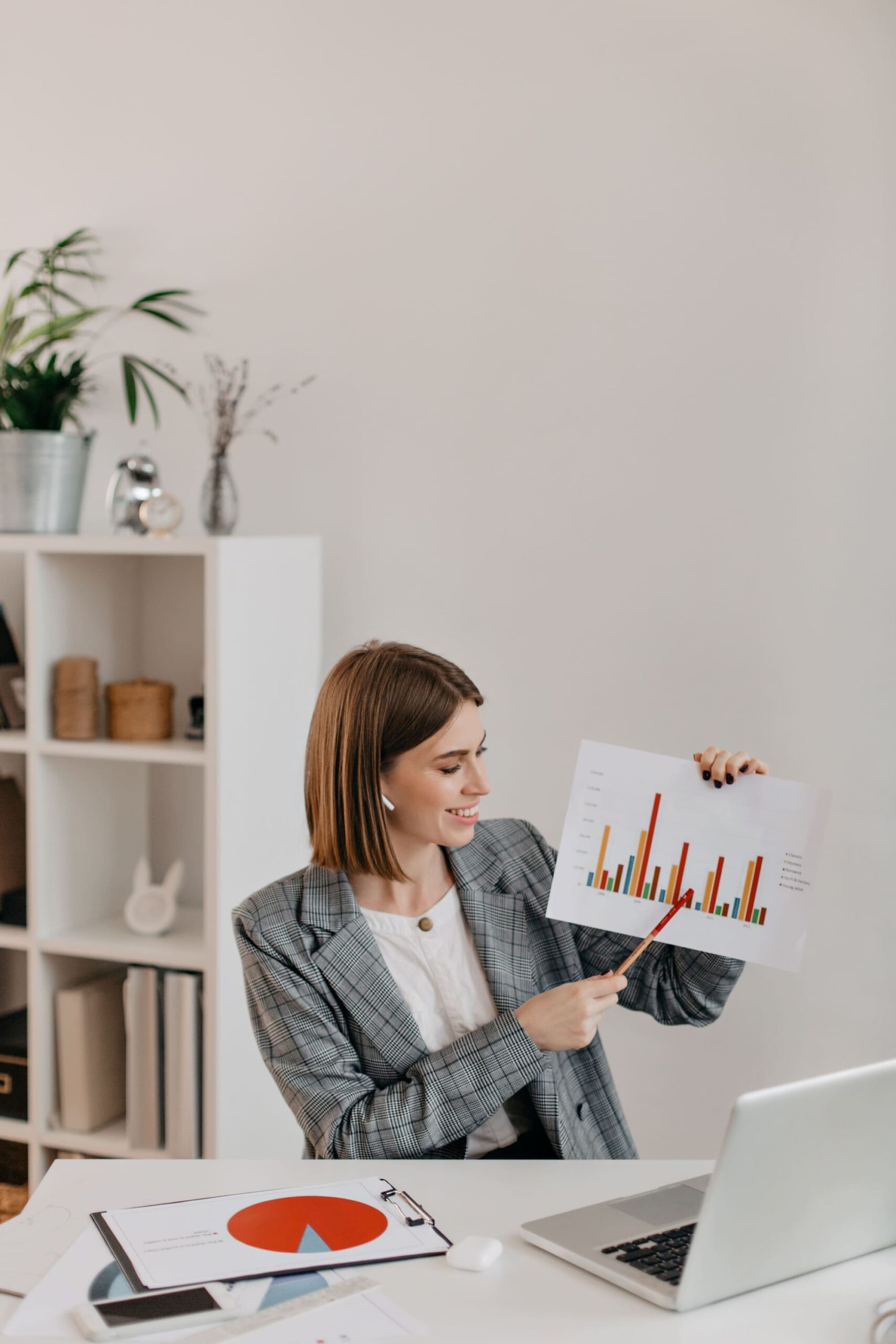 young-business-woman-white-office-with-smile-shows-graphic-talking-customers-skype